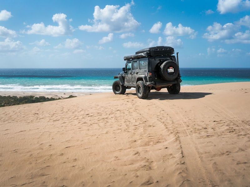 A jeep parked on a beach near the sea